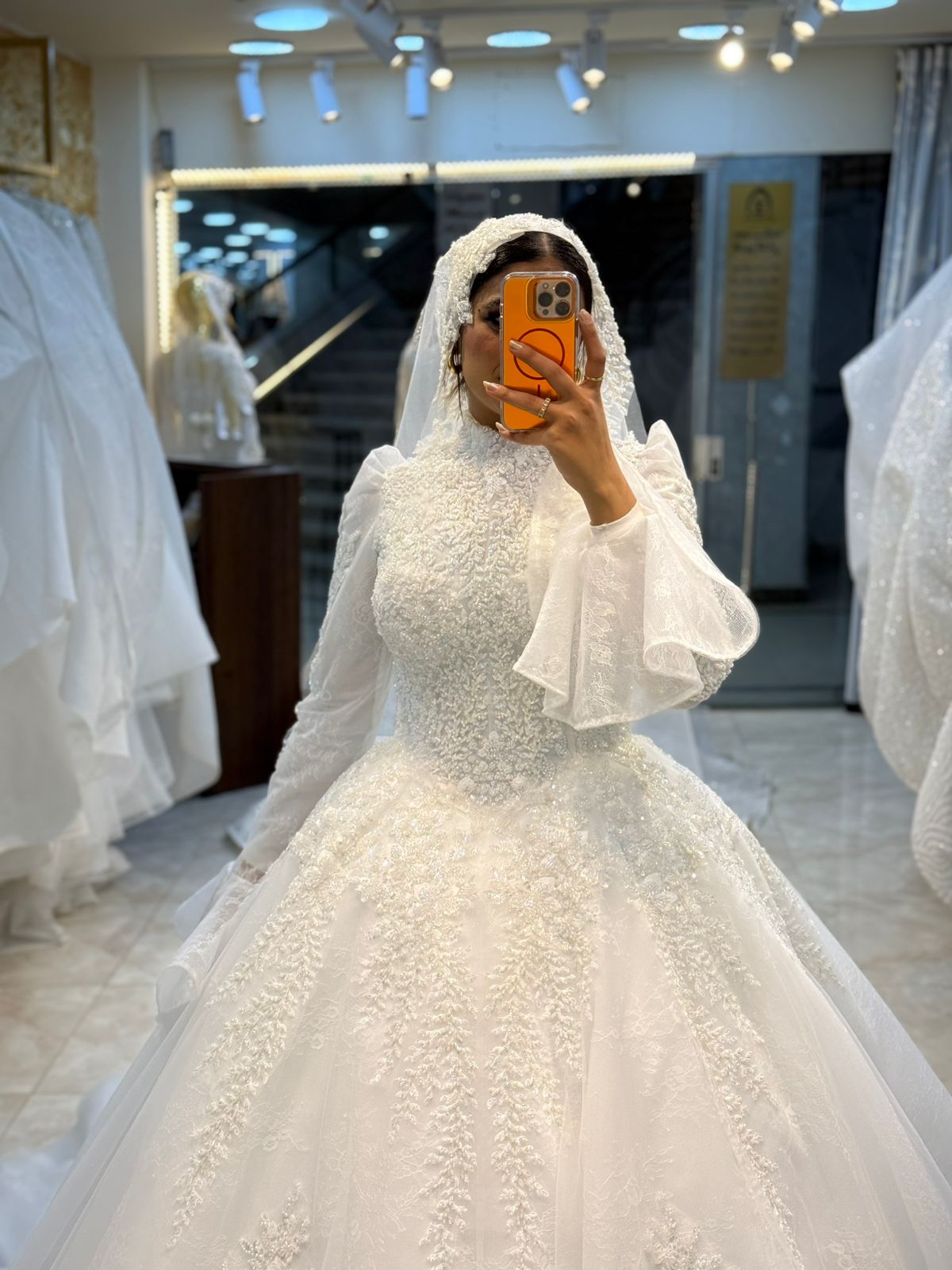 فستان زفاف ملكي بتطريز لؤلؤي وأكمام شفافة فاخرة