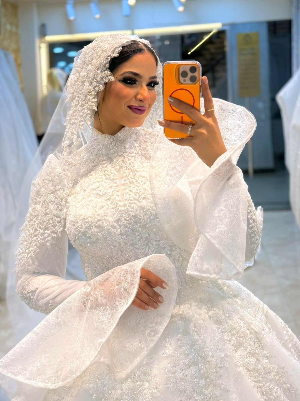 فستان زفاف ملكي بتطريز لؤلؤي وأكمام شفافة فاخرة